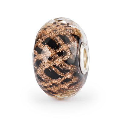 Criss crossing golden glitter light up this black, faceted glass bead. Like gold fireworks as the clock strikes midnight.