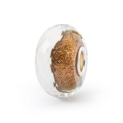 Winter Clouds glass bead has a faceted shape. One side of the bead has glimmering earthy tones and the other one is white like snow, symbolizing the beauty of winter.
